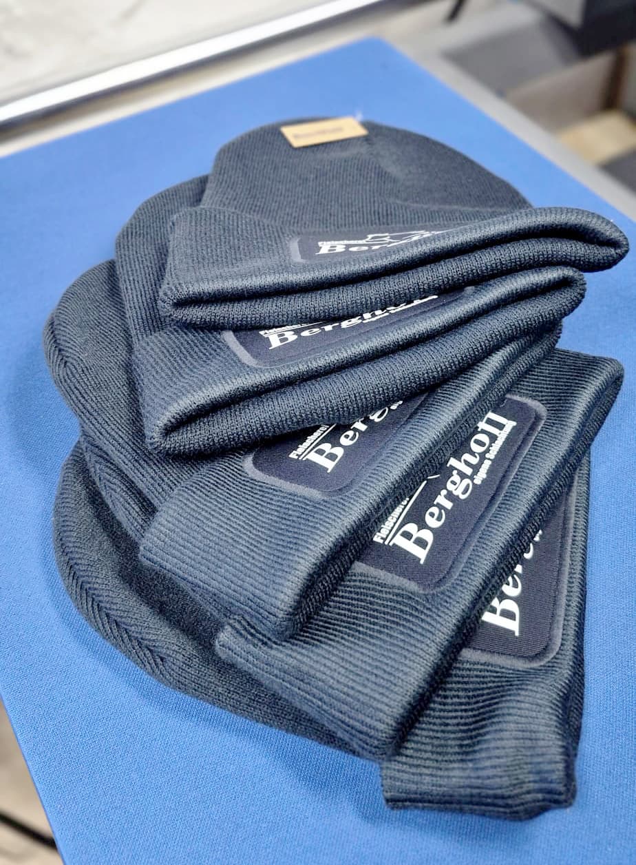 Dunkelblaue Strickmützen mit eingenähtem Logo-Label der Fleischerei