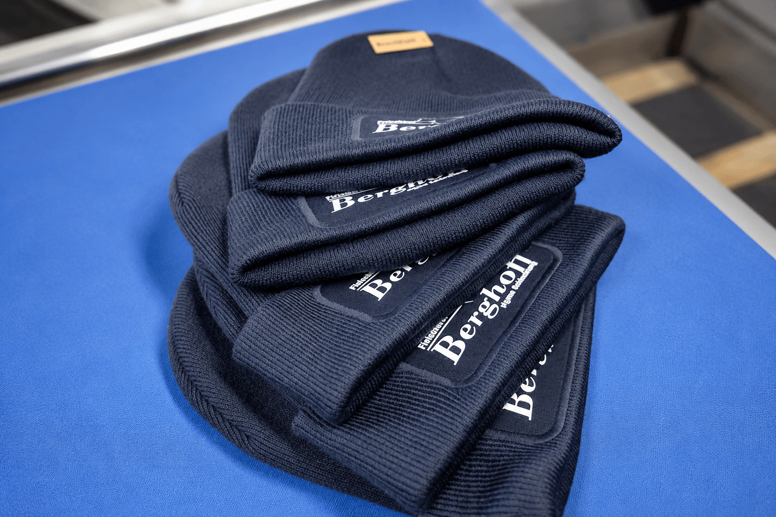 Dunkelblaue Strickmützen mit eingenähtem Patch, Logo-Label aufgedruckt der Fleischerei