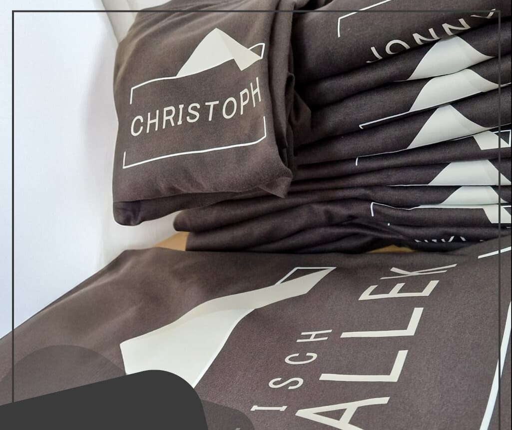 Detailansicht der bedruckten Stammtisch-Shirts mit Bergmotiv und Namen